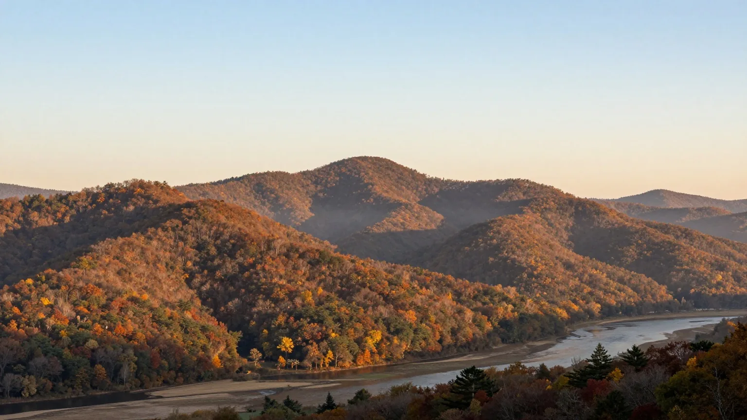 Bewaldete Bergrücken der südlichen Appalachen über einem stillen Flusstal im warmen Licht der späten Nachmittagssonne